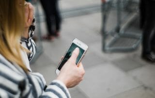 Kvinna håller en mobiltelefon